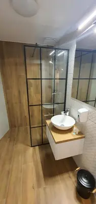 a bathroom with a sink and a glass shower at Dom Pod Groniem in Rzyki