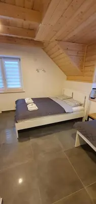 a large bed in a room with a wooden ceiling at Dom Pod Groniem in Rzyki