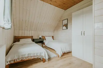 a bed in a room with a wooden ceiling at Domki Dobre Miejsce in Rabka