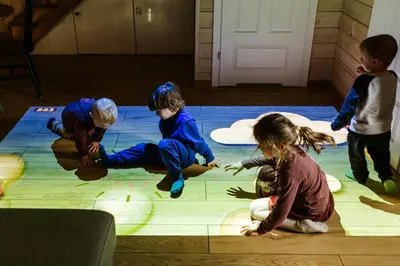 two children are laying on the floor with colored lights at Domki Dobre Miejsce in Rabka