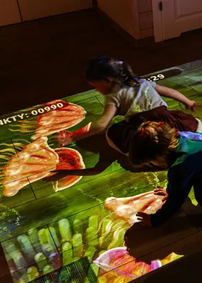 two children playing on a rug on the floor in a kitchen at Domki Dobre Miejsce in Rabka