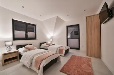 a bedroom with two beds and a mirror at Domki Pod Lasem MM in Rabka