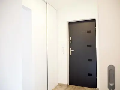 a black door in a white room with a mirror at Telimeny in Kraków