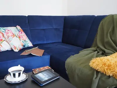a blue couch with a table with a tablet on it at Telimeny in Kraków
