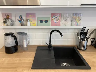 a kitchen counter with a black sink and a counter top with a counter at Duo 1 Debniki Cozy Kraków Base 10-min to Wawel & Kazimierz Fast Wi-Fi in Kraków