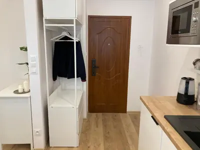 a kitchen with a refrigerator and a wooden door at Duo 1 Debniki Cozy Kraków Base 10-min to Wawel & Kazimierz Fast Wi-Fi in Kraków