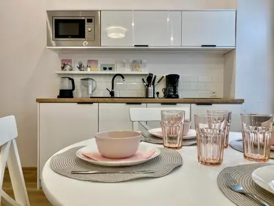 a kitchen with a table with a bowl and glasses at Duo 1 Debniki Cozy Kraków Base 10-min to Wawel & Kazimierz Fast Wi-Fi in Kraków