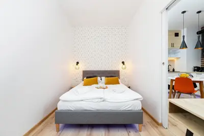 a bedroom with a bed and a kitchen at Cosy Apartment at the Main Station by Noclegi Renters in Kraków