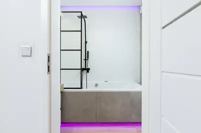 a bathroom with a bath tub with a mirror at Cosy Apartment at the Main Station by Noclegi Renters in Kraków
