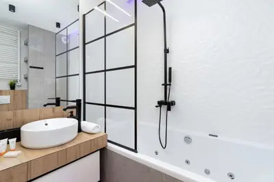 a bathroom with a white sink and a shower at Cosy Apartment at the Main Station by Noclegi Renters in Kraków