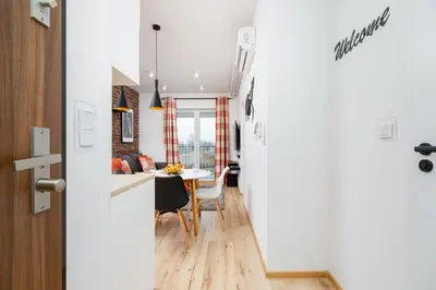 a kitchen and dining room with a table and chairs at Cosy Apartment at the Main Station by Noclegi Renters in Kraków