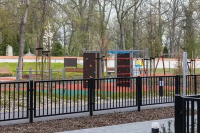 a playground in a park with a black fence at Cosy Apartment at the Main Station by Noclegi Renters in Kraków