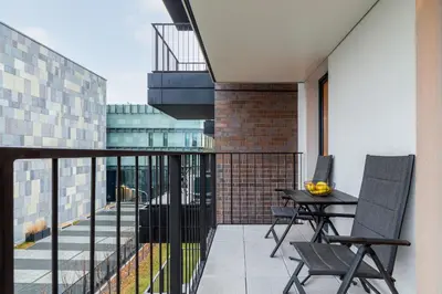 a balcony with a table and chairs on it at Cosy Apartment at the Main Station by Noclegi Renters in Kraków