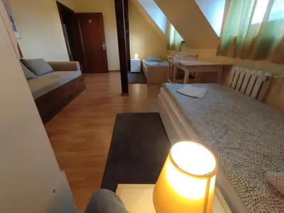 a living room with a bed and a table with a lamp at Centro Unita in Kraków