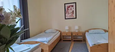 a small room with two beds and a plant at Centro Unita in Kraków