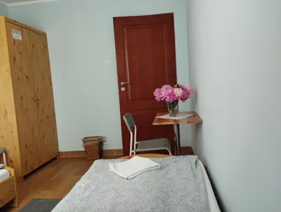 a room with a table and a vase of pink flowers at Centro Unita in Kraków