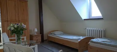 a bedroom with two beds and a table with a vase of flowers at Centro Unita in Kraków