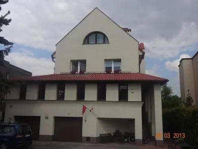 a white building with a red roof and a window at Centro Unita in Kraków
