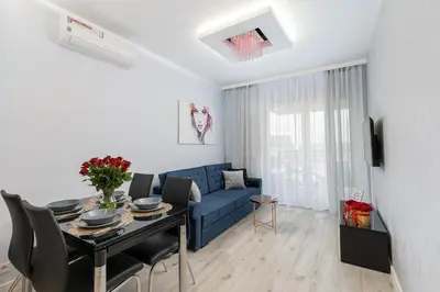 a living room with a blue couch and a table at Angel Apartments 1 in Kraków