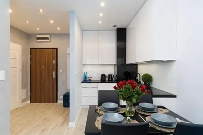 a kitchen and dining room with a table and chairs at Angel Apartments 1 in Kraków