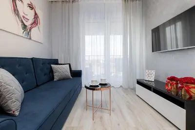 a living room with a blue couch and a table at Angel Apartments 1 in Kraków