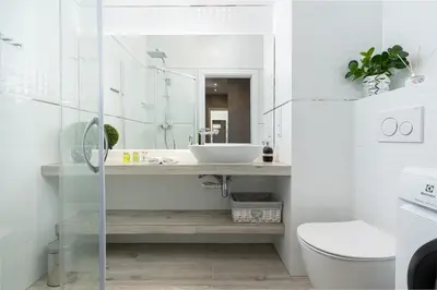 a white bathroom with a sink and a toilet at Angel Apartments 1 in Kraków
