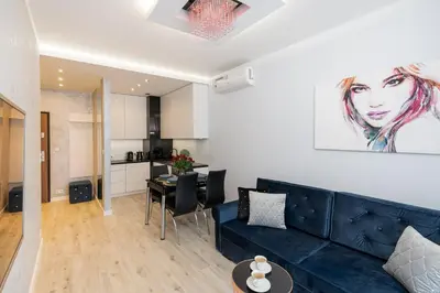a living room with a blue couch and a table at Angel Apartments 1 in Kraków