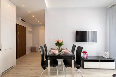 a dining room with a black table and black chairs at Angel Apartments 2 in Kraków