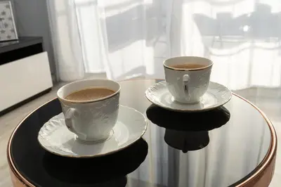 two cups of coffee sitting on a glass table at Angel Apartments 2 in Kraków