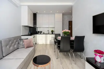 a living room and kitchen with a couch and a table at Angel Apartments 2 in Kraków