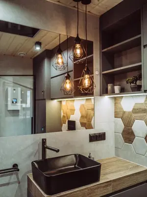 a bathroom with a black sink and pendant lights at CzillChata - dom z balią in Maków Podhalański