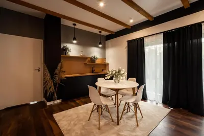a dining room with a table and chairs and a kitchen at Boski Zakątek in Wielka Wieś