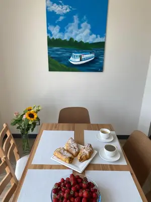 a table with a plate of food and a boat on the water at HamakoweLove in Dąbrówka