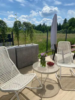 three chairs and a table on a patio at HamakoweLove in Dąbrówka