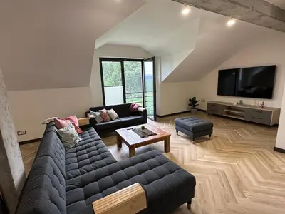 a living room with a couch and a tv at HamakoweLove in Dąbrówka