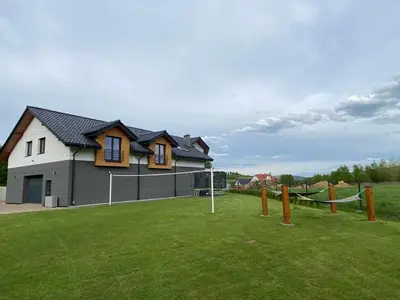 a house with a tennis court in a field at HamakoweLove in Dąbrówka