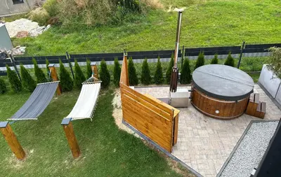 a group of chairs and a wooden tub in a yard at HamakoweLove in Dąbrówka