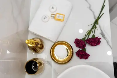 a table topped with gold rings and purple flowers at Glossy Apart G9 in Kraków