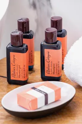 three bottles of essential oils and a plate with a piece of soap at Mogilska Apartments by Renters Prestige in Kraków