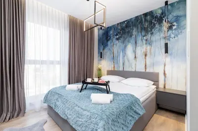 a bedroom with a bed with a blue painting on the wall at Mogilska Apartments by Renters Prestige in Kraków