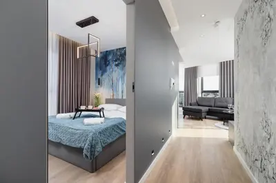 a bedroom with a bed and a living room at Mogilska Apartments by Renters Prestige in Kraków