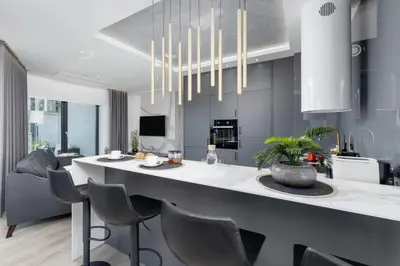 a kitchen and living room with a large island with chairs at Mogilska Apartments by Renters Prestige in Kraków