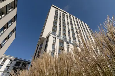 a tall white building with trees in front of it at Mogilska Apartments by Renters Prestige in Kraków