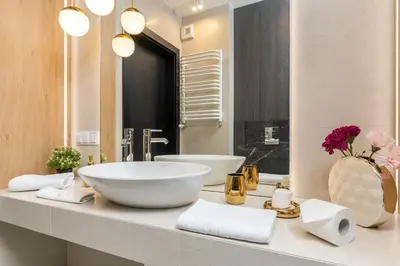 a bathroom with a bowl sink and a mirror at Glossy Apart G20 in Kraków