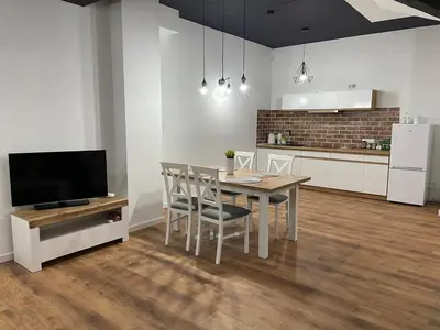 a kitchen and dining room with a table and a television at Apartament Rynek 13 z parkingiem - Centrum Bochni in Bochnia