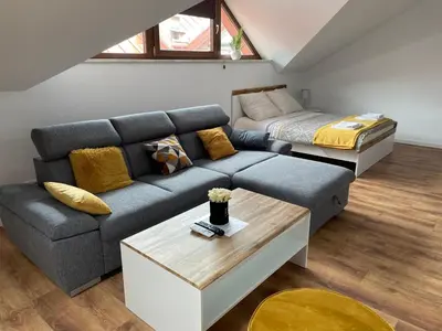 a living room with a couch and a bed at Apartament Rynek 13 z parkingiem - Centrum Bochni in Bochnia