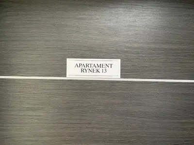 a metal door with a sign that reads apartment knake b at Apartament Rynek 13 z parkingiem - Centrum Bochni in Bochnia