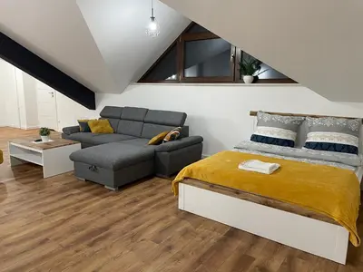 a bedroom with a bed and a couch at Apartament Rynek 13 z parkingiem - Centrum Bochni in Bochnia
