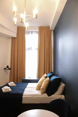 a bedroom with a bed with pillows and a window at EURO-ROOM in Kraków