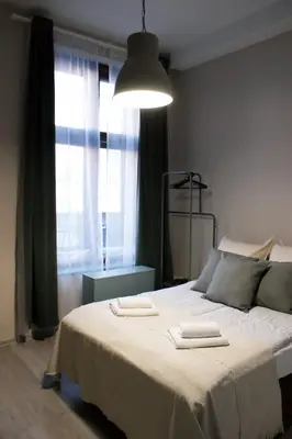 a bedroom with a large bed with two towels on it at EURO-ROOM in Kraków